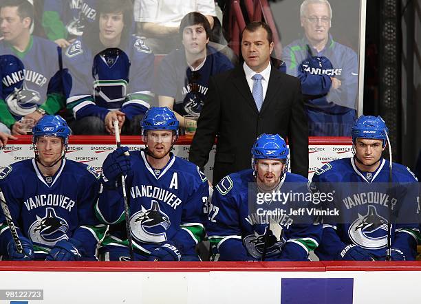 Henrik Sedin, Daniel Sedin, Jannik Hansen, Darcy Hordichuk and Head coach Alain Vigneault of the Vancouver Canucks look on from the bench during...