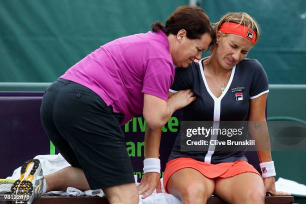 Svetlana Kuznetsova of Russia is worked on by a trainer while playing against Marion Bartoli of France during day seven of the 2010 Sony Ericsson...