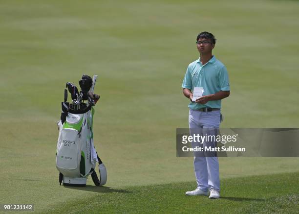 Zecheng Dou of China stands with his new bag on the 18th hole during the second round of the Travelers Championship at TPC River Highlands on June...