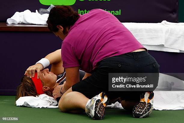 Svetlana Kuznetsova of Russia is worked on by a trainer while playing against Marion Bartoli of France during day seven of the 2010 Sony Ericsson...