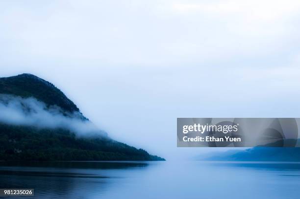 fog over lake among forest covered hills, highlands, scotland, uk - loch ness stock pictures, royalty-free photos & images