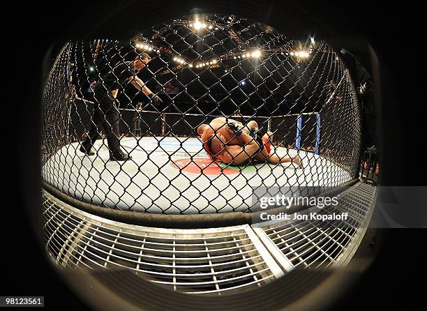 Fighter Georges St-Pierre battles Dan Hardy while the referee looks on during their Welterweight title bout at UFC 111 at the Prudential Center on...