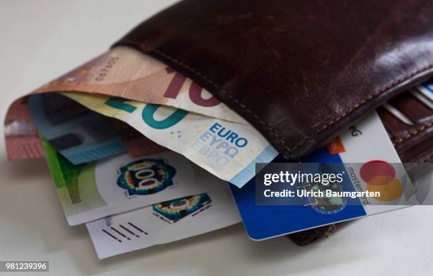 Cash or credit card - which method of payment will prevail in the future? The picture shows a purse with euro banknotes and a Mastercard credit card.