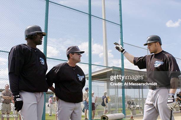 Toronto Blue Jays manager Carlos Tosca watches batting drills with sluggers Carlos Delgado and Eric Hinske during practice March 3, 2004 in Dunedin,...