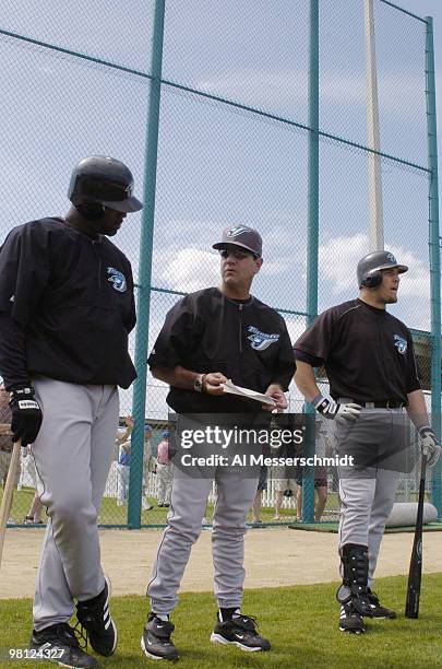 Toronto Blue Jays manager Carlos Tosca watches batting drills with sluggers Carlos Delgado and Eric Hinske during practice March 3, 2004 in Dunedin,...
