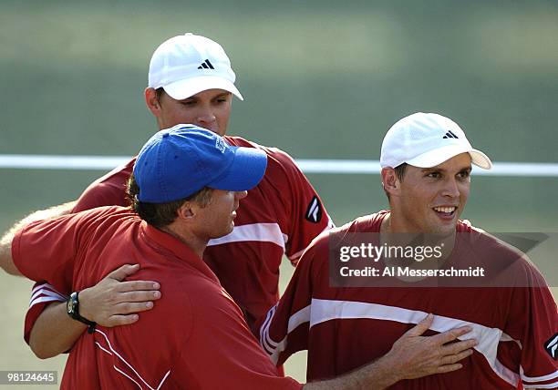 United States doubles partners Bob and Mike Bryan hug captain Patrick McEnroe in the Davis Cup quarter finals in Delray Beach, Florida April 10,...