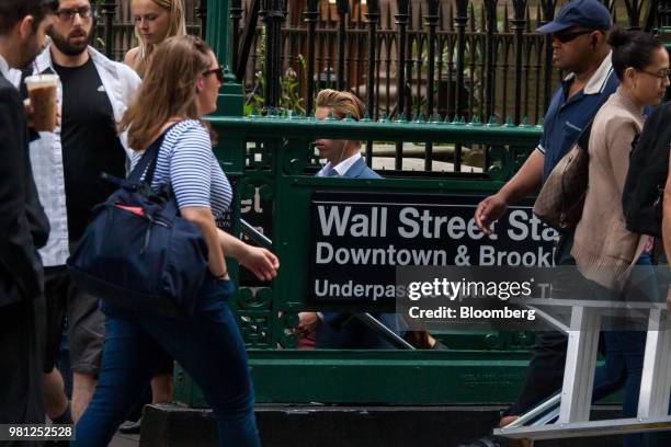 Pedestrians pass the Wall Street subway station near the New York Stock Exchange in New York, U.S., on Friday, June 22, 2018. U.S. Stocks climbed...