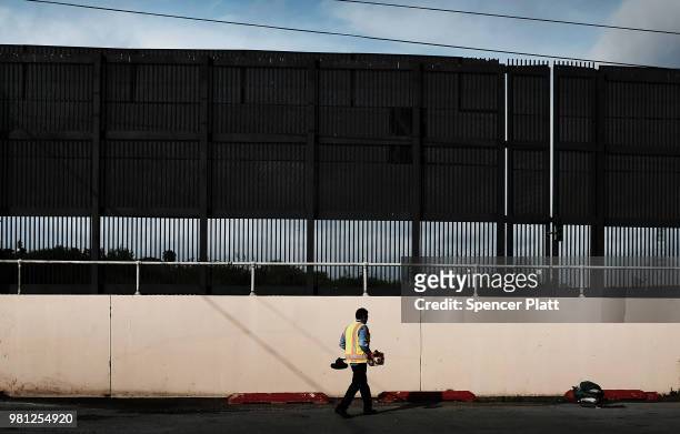 City worker cleans an area under the border wall in downtown Brownsville, a border city which has become dependent on the daily crossing into and out...