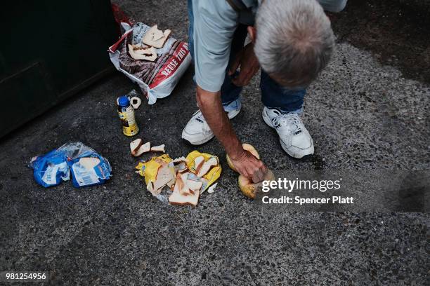 Homeless man looks for food in the garbage along a street in downtown Brownsville, a border city which has become dependent on the daily crossing...