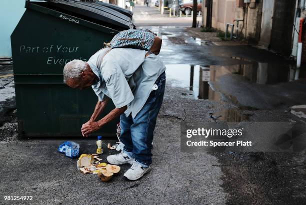 Homeless man looks for food in the garbage along a street in downtown Brownsville, a border city which has become dependent on the daily crossing...