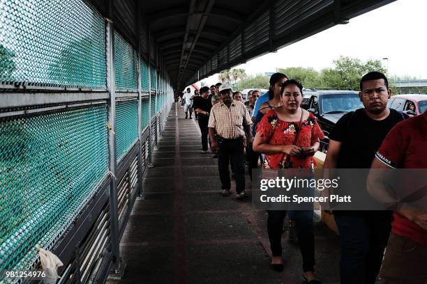 Mexican residents wait to make the daily crossing into the American border city of Brownsville, a city which has become dependent on the daily...