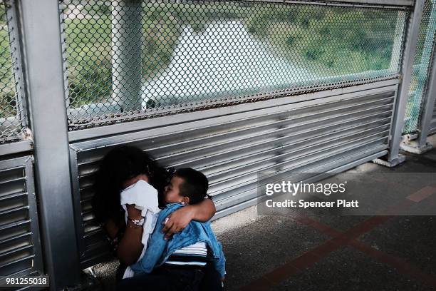 Crying Honduran woman and her child wait along the border bridge after being denied into the Texas city of Brownsville which has become dependent on...