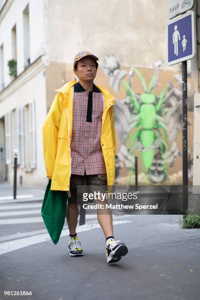 Kaname Murakami is seen on the street during Paris Men's Fashion Week S/S 2019 wearing a yellow coat with red/navy plaid shirt and green bag on June...