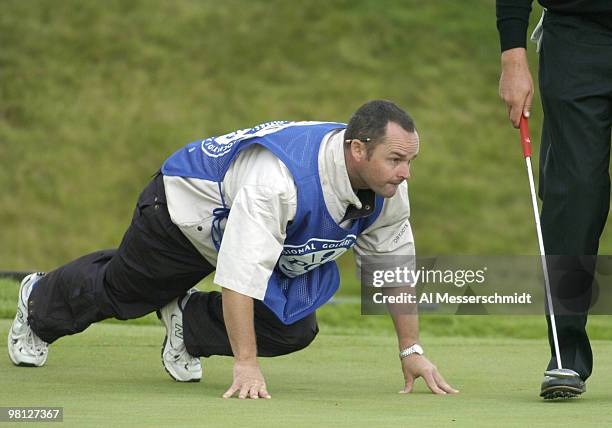 Darren Clarke's caddy is in the blocks, lining up a putt on the 18th green, at Whistling Straits, site of the 86th PGA Championship in Haven,...