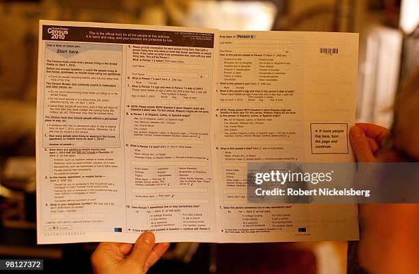 Woman looks through a 2010 census form March 18, 2010 in Brooklyn, New York. The Census Bureau mailed a questionnaire to134 million US households...