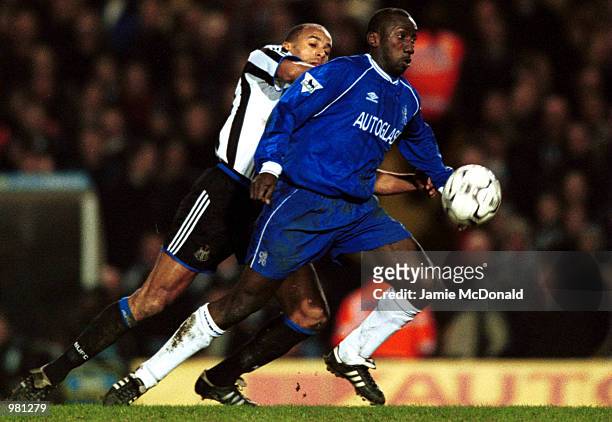 Jimmy Floyd Hasselbaink of Chelsea fends of Alain Goma during the FA Carling Premiership match between Chelsea and Newcastle United played at...