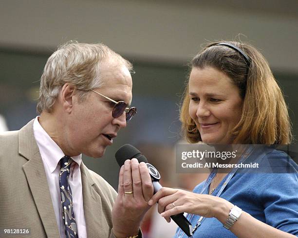 Comedian Chevy Chase checks TV commentator Pam Shriver's microphone as Roger Federer defeats Tim Henman, 6-3, 6-4, 6-4, in a semi final, men's...