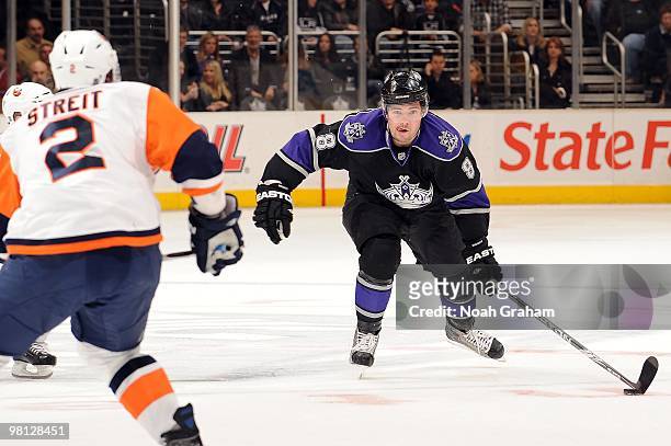 Drew Doughty of the Los Angeles Kings skates with the puck against Mark Streit of the New York Islanders at Staples Center on March 20, 2010 in Los...