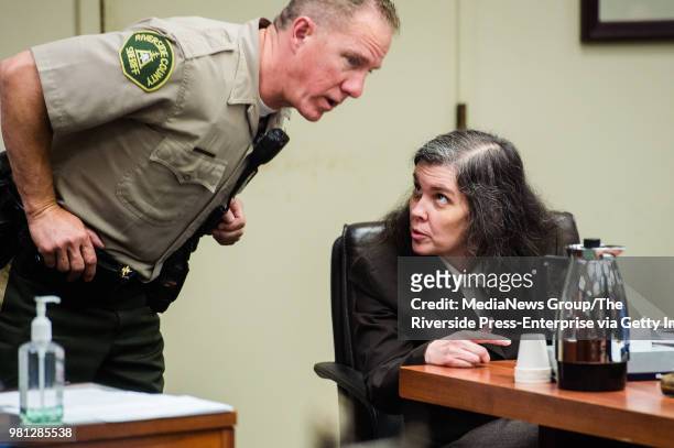Louise Turpin, left, talks to a bailiff as she appears in Superior Court in Riverside County, Calif. On Wednesday, June 20, 2018 for a preliminary...