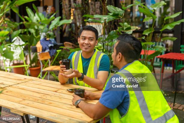 zwei asiatische männer sprechen auf ein café im freien - straßencafe stock-fotos und bilder