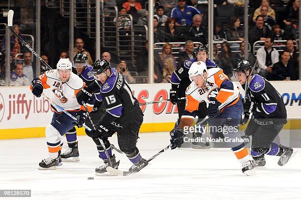 Brad Richardson of the Los Angeles Kings skates with the puck beween Josh Bailey and Kyle Okposo of the New York Islanders at Staples Center on March...