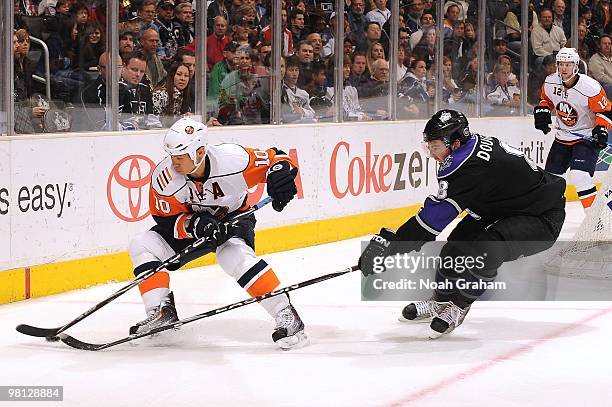 Richard Park of the New York Islanders skates with the puck while Drew Doughty of the Los Angeles Kings reaches in during their game at Staples...