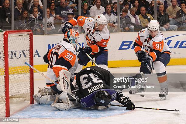 Fredrik Modin of the Los Angeles Kings loses his balance in front of the goal against Dwayne Roloson, Freddy Meyer, and John Tavares of the New York...