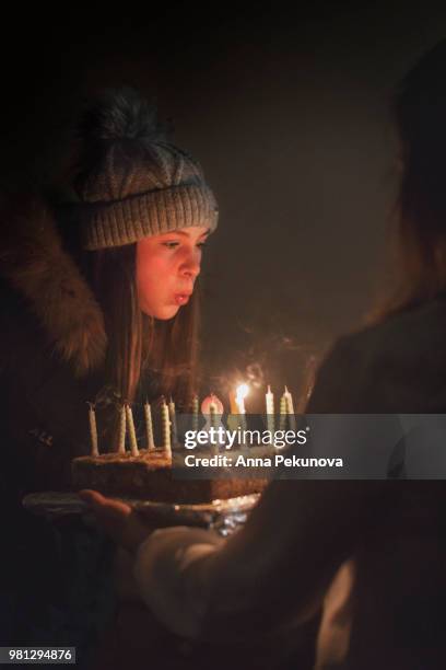 teenage girl blowing out birthday candles - anna pekunova stock-fotos und bilder