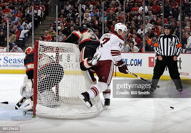 Radim Vrbata of the Phoenix Coyotes sandwiches Dave Bolland of the Chicago Blackhawks against the net, while going after the puck, on March 23, 2010...
