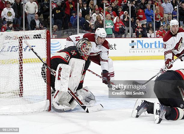 Goalie Antti Niemi of the Chicago Blackhawks and Taylor Pyatt of the Phoenix Coyotes wait in position in front of the net on March 23, 2010 at the...