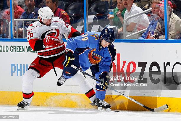 Tobias Enstrom of the Atlanta Thrashers battles for the puck against Erik Cole of the Carolina Hurricanes at Philips Arena on March 29, 2010 in...