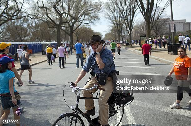 Photographer speaks on his cell phone on The Mall March 21, 2010 during a Immigration Reform Rally in Washington, DC. Cell phone subscribers in the...