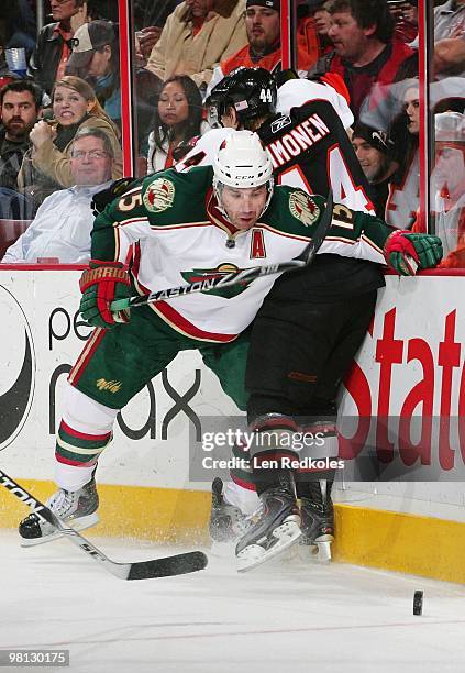 Kimmo Timonen of the Philadelphia Flyers is checked along the boards by Andrew Brunette of the Minnesota Wild as he battles for the puck along the...