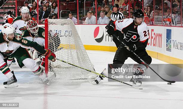 Ville Leino of the Philadelphia Flyers handles the puck from behind his net against Brent Burns and Niklas Backstrom of the Minnesota Wild on March...