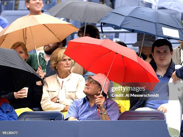 Tennis fans seek refuge from the rain as Marat Safin is matched against Tommy Haas in a fourth-round men's singles match September 5, 2006 during the...