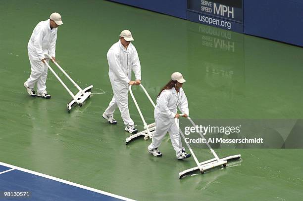 Workers clear the court as rain delays the Marat Safin - Tommy Haas fourth-round men's singles match September 5, 2006 during the 2006 US Open in...