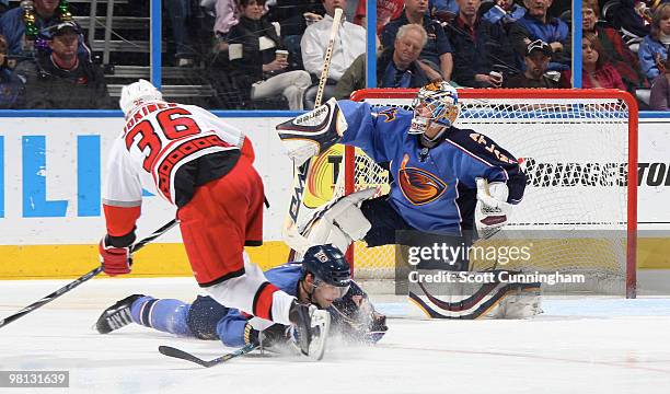 Johan Hedberg of the Atlanta Thrashers makes a save against Jussi Jokinen of the Carolina Hurricanes at Philips Arena on March 29, 2010 in Atlanta,...