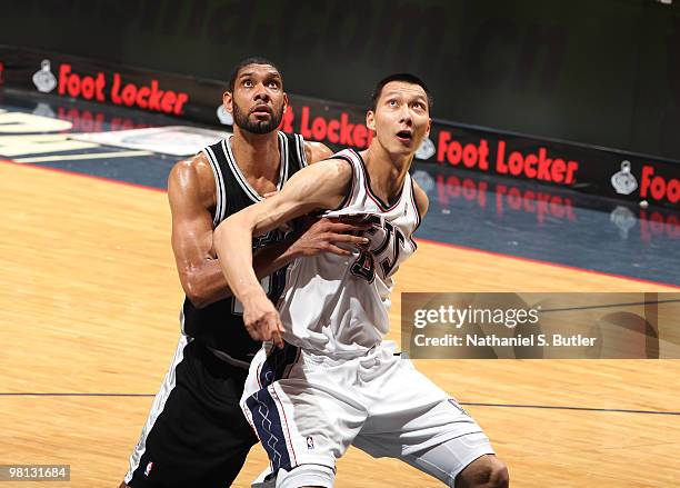 Yi Jianlian of the New Jersey Nets defends against Tim Duncan of the San Antonio Spurs on March 29, 2010 at the IZOD Center in East Rutherford, New...