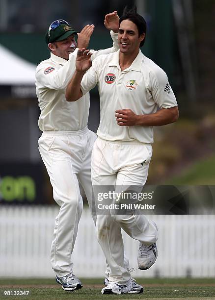 Mitchell Johnson of Australia is congratulated by Michael Hussey after bowling Tim McIntosh of New Zealand during day four of the Second Test match...