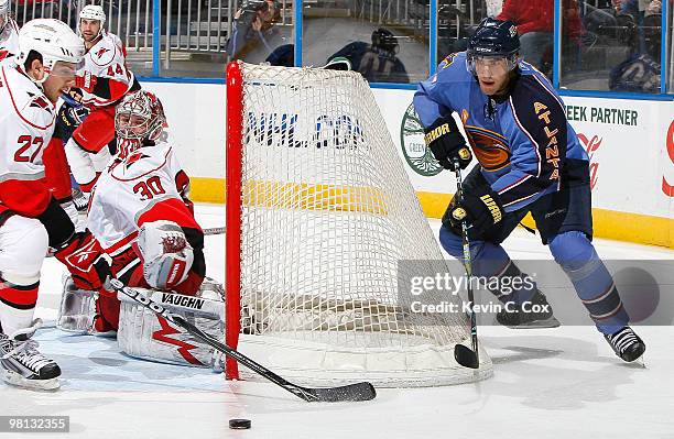 Goaltender Cam Ward of the Carolina Hurricanes defends as Brett Carson breaks up a pass by Mark Popovic of the Atlanta Thrashers at Philips Arena on...