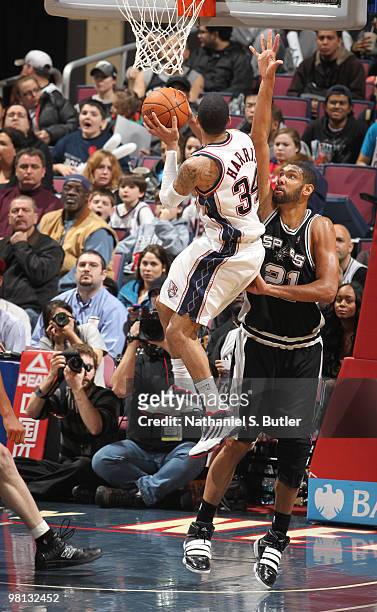 Devin Harris of the New Jersey Nets shoots against Tim Duncan of the San Antonio Spurs on March 29, 2010 at the IZOD Center in East Rutherford, New...