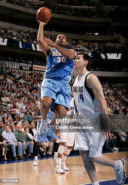 Malik Allen of the Denver Nuggets puts up a shot against Eduardo Najera of the Dallas Mavericks during a game at the American Airlines Center on...