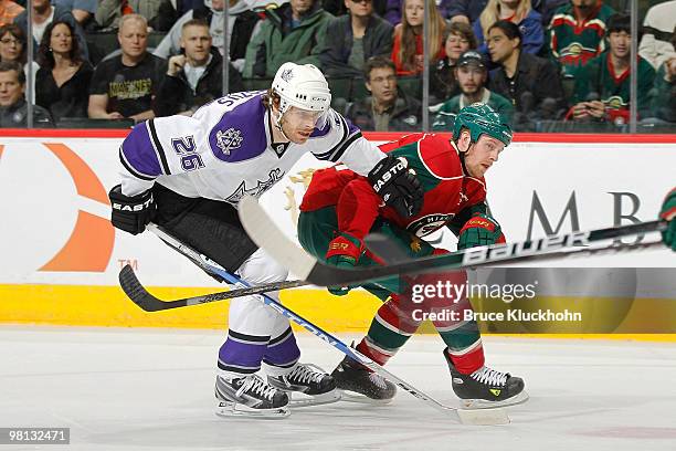 Kyle Brodziak of the Minnesota Wild and Michal Handzus of the Los Angeles Kings skate to the puck during the game at the Xcel Energy Center on March...