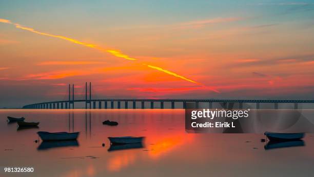 oresund bridge at sunset, malmo, sweden - öresundsregionen stock-fotos und bilder