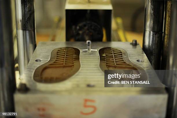 The soles of a pair of Dr Martens boots are moulded in the Dr Martens factory in Wellingborough, Northamptonshire, in central England, on March 18,...