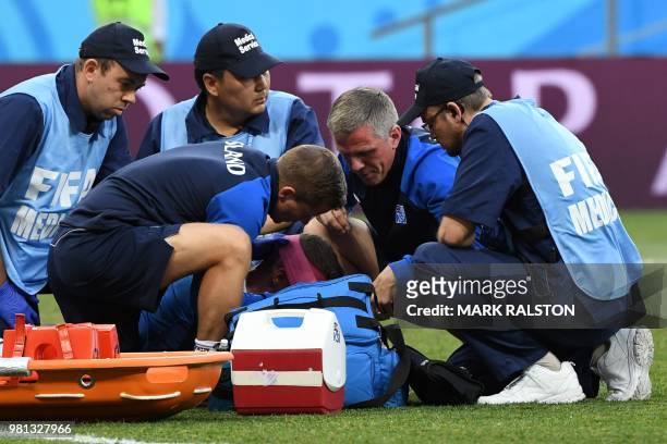 Iceland's defender Ragnar Sigurdsson is treated by medical staff after a collision during the Russia 2018 World Cup Group D football match between...