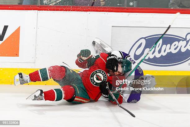 Cal Clutterbuck of the Minnesota Wild is taken down by Peter Harrold of the Los Angeles Kings during the game at the Xcel Energy Center on March 29,...