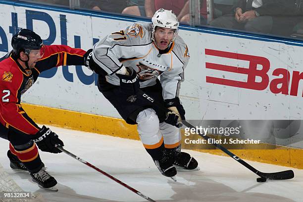 Dumont of the Nashville Predators skates with the puck against Keith Ballard of the Florida Panthers at the BankAtlantic Center on March 29, 2010 in...