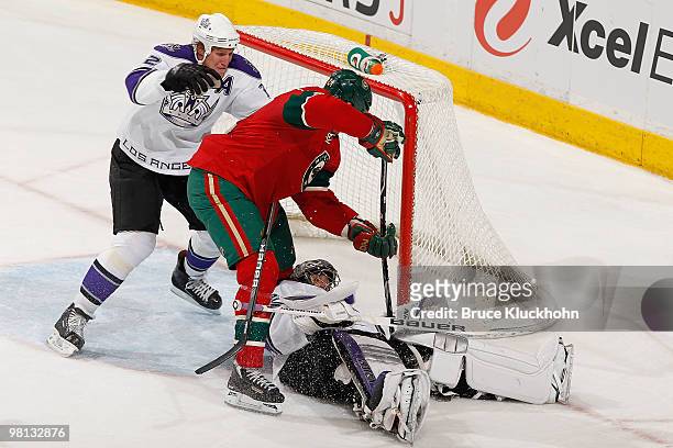Jonathan Quick of the Los Angeles Kings covers up the puck while his teammate Matt Greene prevents Derek Boogaard of the Minnesota Wild from knocking...