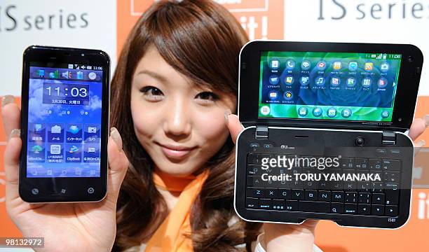Model shows off the new smartphone "IS01" built on the Android operating system and the "IS02" built on the Windows operating system during a press...